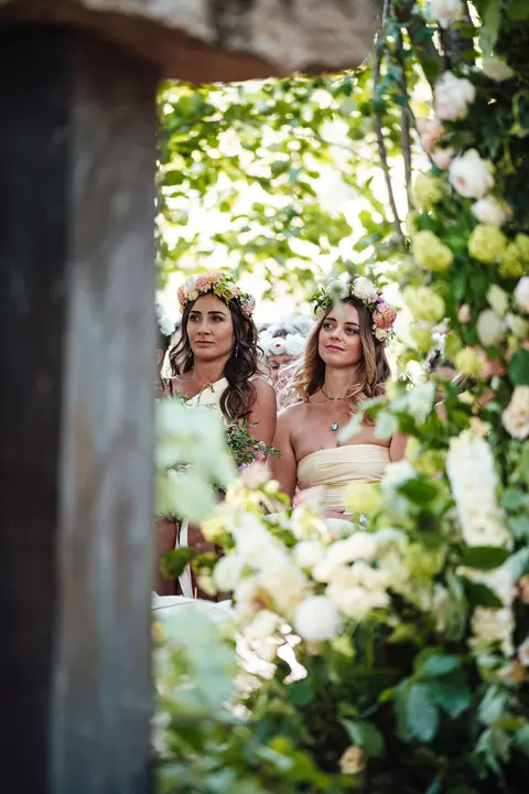Bridesmaids in flower crowns glimpsed through white roses