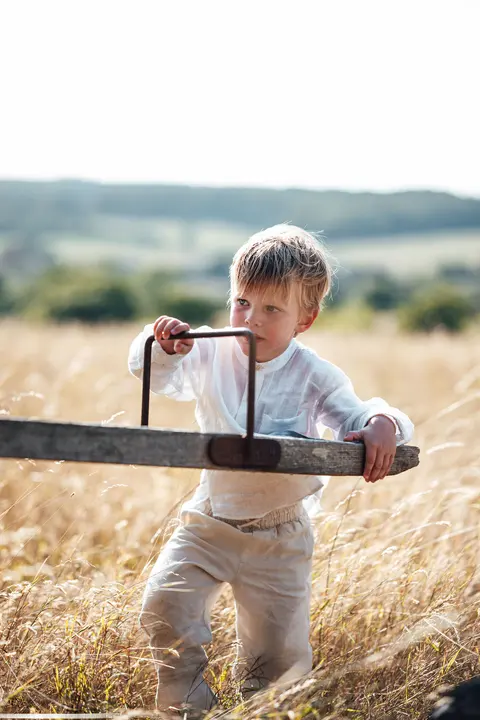 A boy balancing on the old seesaw in the field
