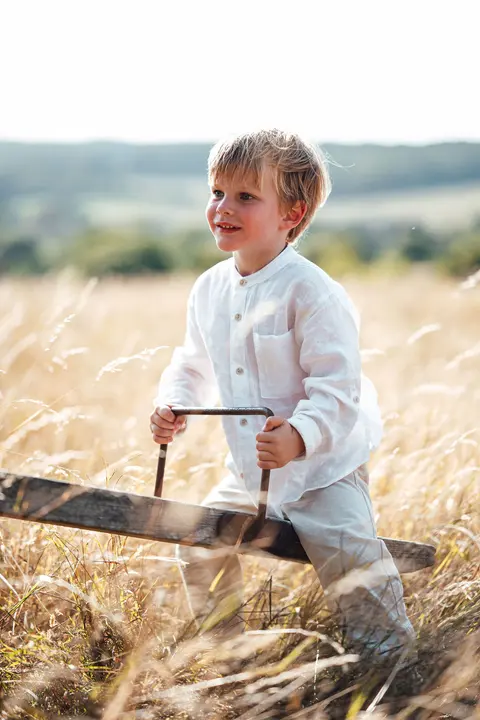 A boy on the seesaw looking up through the grass