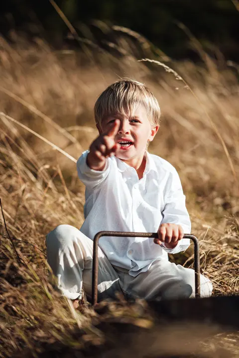 A boy pointing at the camera from the seesaw