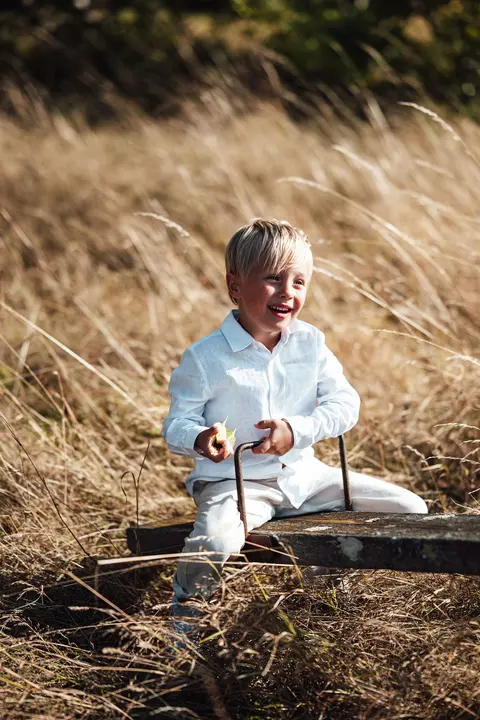 A boy standing in the field, side on