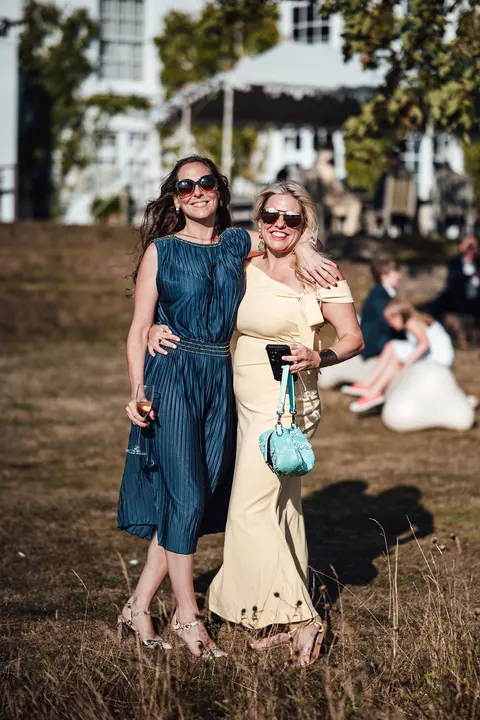 A group of guests smiling together in the long grass