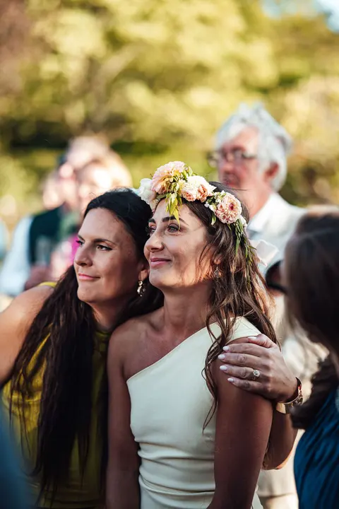 Two guests hugging, one wearing a flower crown