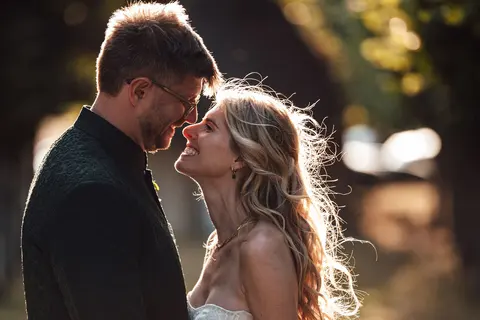 The couple forehead to forehead in low golden backlight