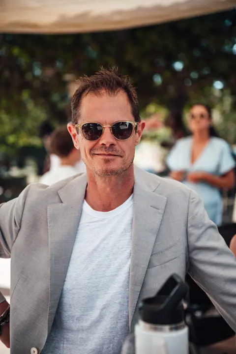 A guest in a grey jacket and sunglasses, candid