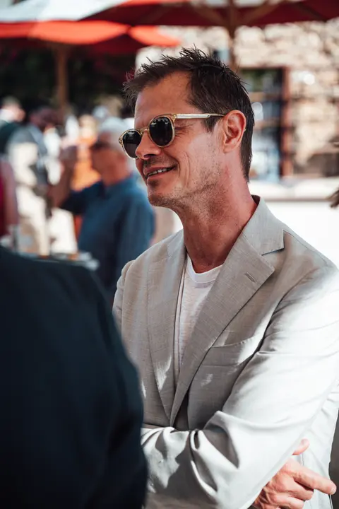 A guest in grey smiling at the party