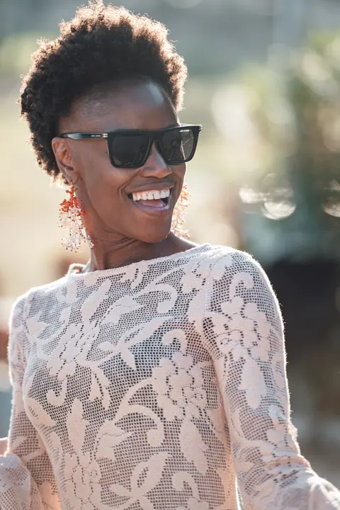 The bride laughing in lace, sunglasses pushed up