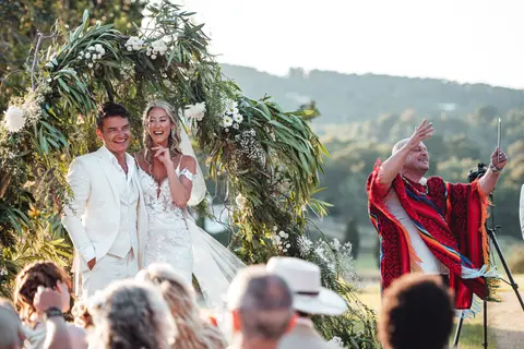 The couple beneath the arch as a flag is waved