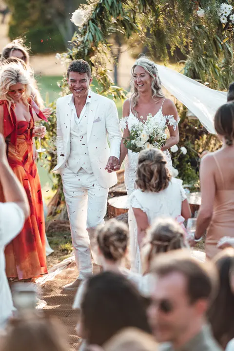 The couple walking back through their guests