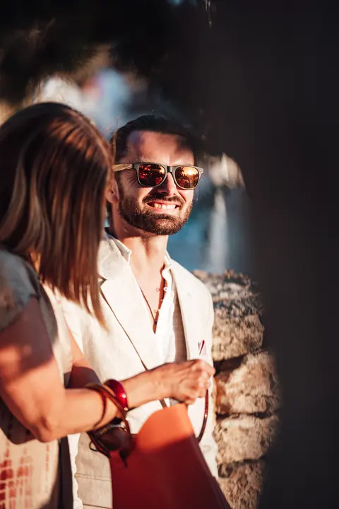 A guest in sunglasses smiling in the evening light