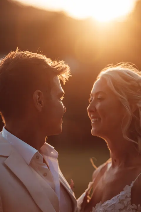 The couple close together in the sunset light