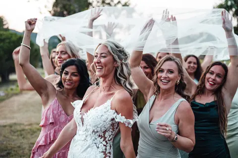 The bride and her friends dancing with the veil held above them