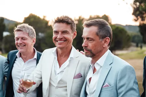 The groom laughing with two friends
