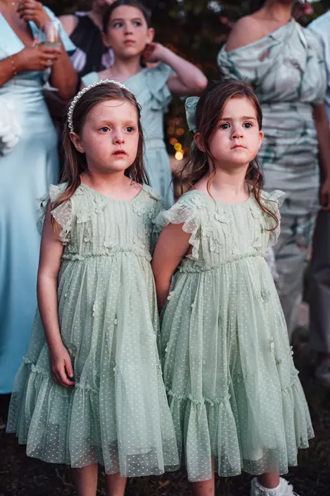 Two flower girls in sage green dresses