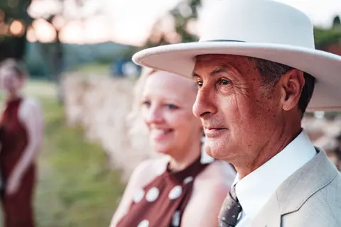 A guest in a white hat watching with a smile