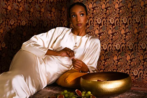 Model lying back beside the brass bowl, seen from above
