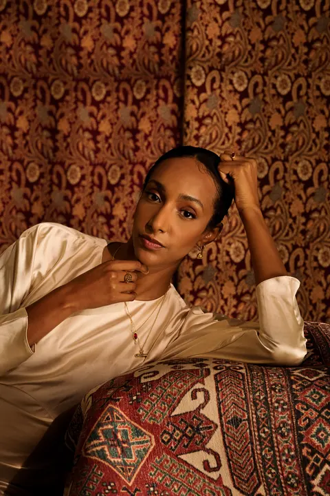 Side profile portrait with a pendant necklace in warm light