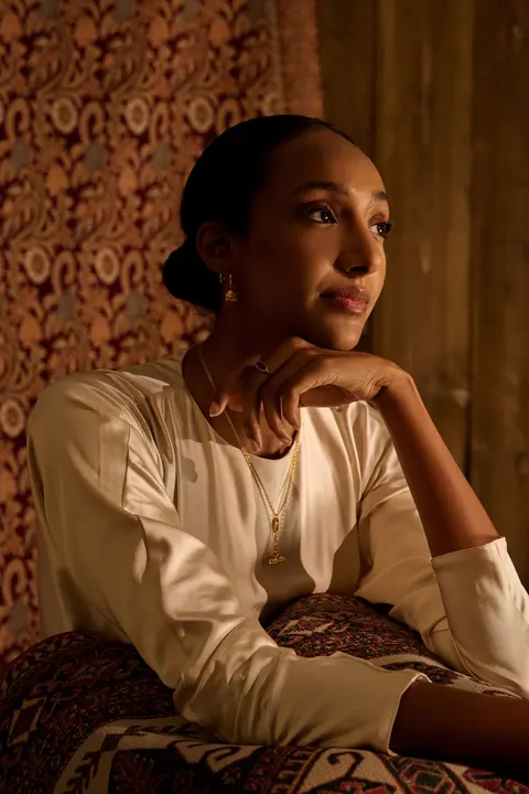 Portrait with her chin on her hand against the patterned wall
