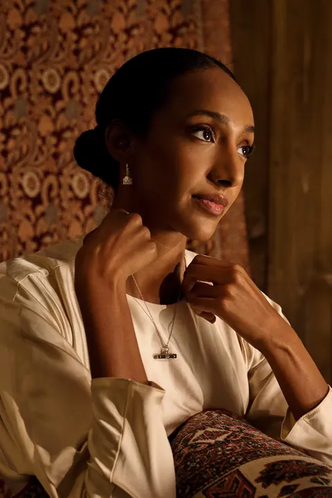 Portrait showing gold earrings and a pendant necklace