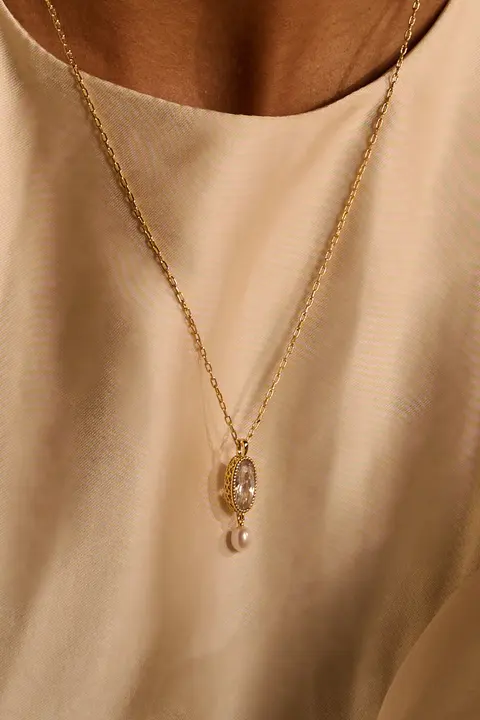 Close detail of a pendant necklace at the collarbone