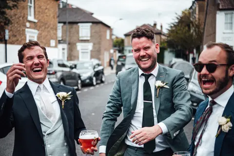 Groomsmen laughing together in a London street