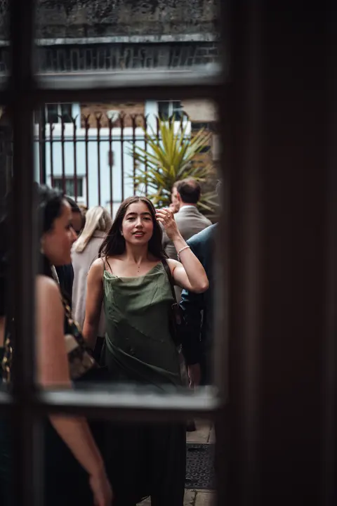 Guests arriving, seen through an iron gate