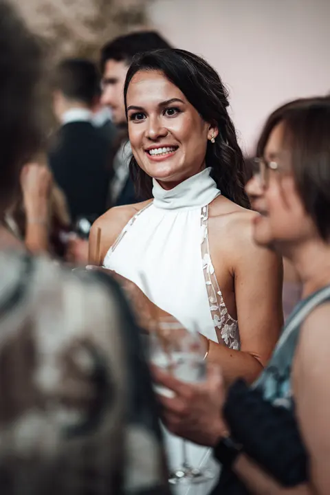 The bride laughing with guests at the reception