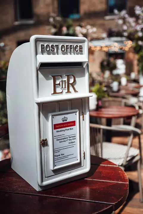 A white post box for cards on a table