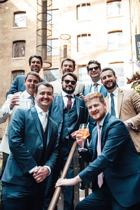 The groom and groomsmen on the courtyard steps
