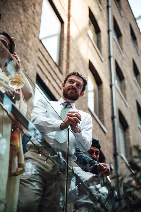 A guest raising a glass on the balcony