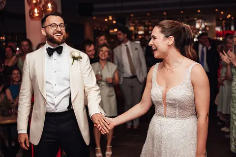 The couple holding hands on the dance floor