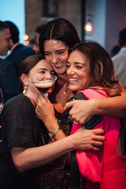 Guests hugging and laughing at the party