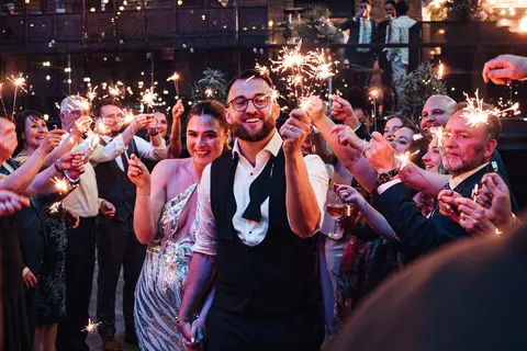 The couple surrounded by guests holding sparklers
