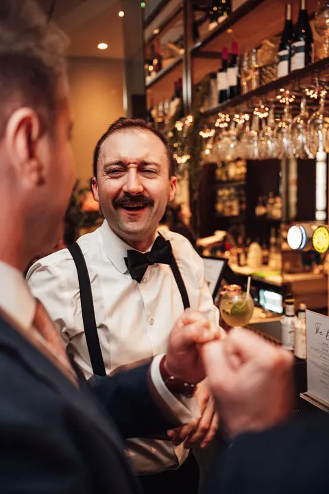 The groom laughing at the bar
