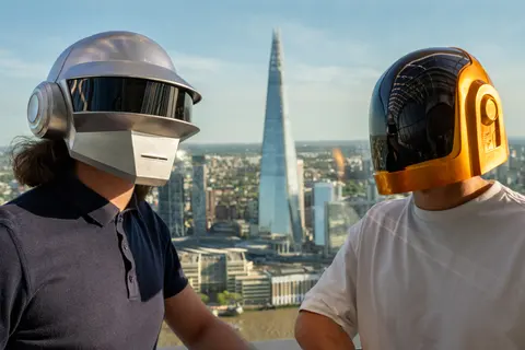 The two DJs in helmets in front of the City skyline