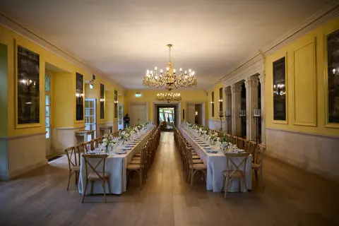 The yellow dining hall laid for lunch, seen from the far end