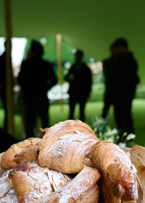 Pastries on a table with guests in silhouette behind