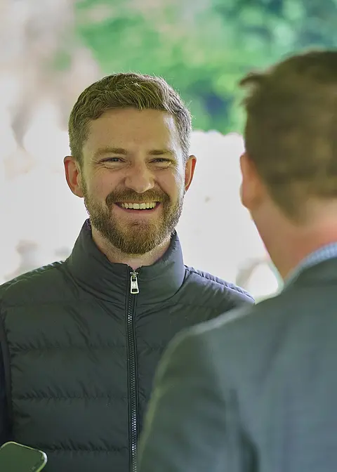 Two guests in conversation under the marquee
