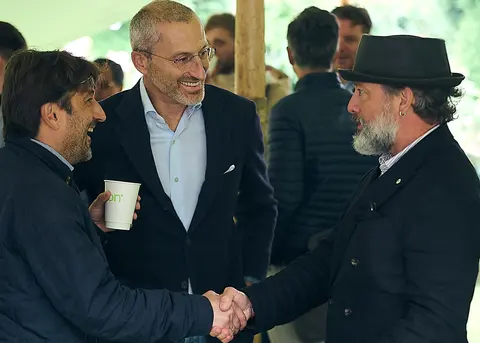 Guests shaking hands and laughing in the garden marquee