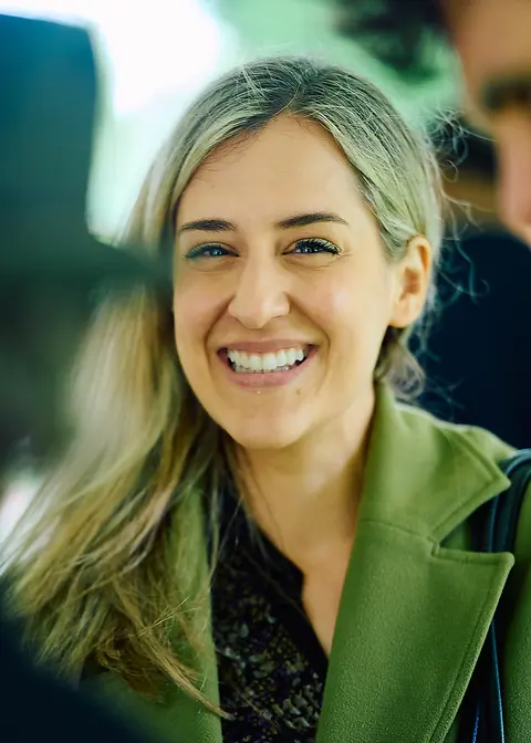 A guest in a plaid shirt smiling under the marquee