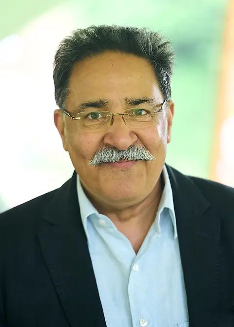 An older guest with glasses and a moustache, smiling