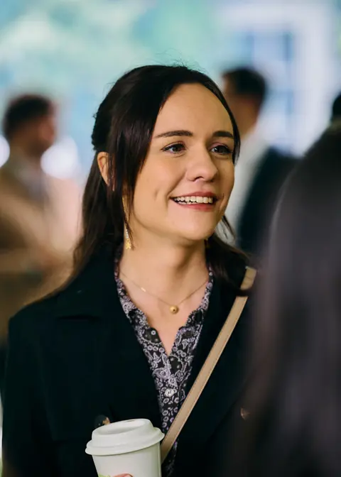 A guest smiling candidly with a coffee cup
