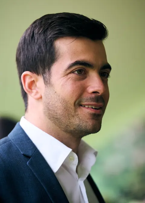 A guest in a sharp navy jacket smiling in profile