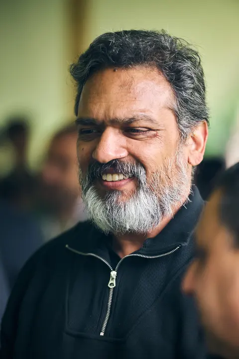 A bearded, grey haired guest smiling