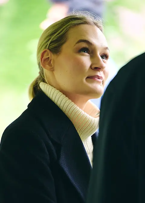 A guest in a cream top looking up, smiling