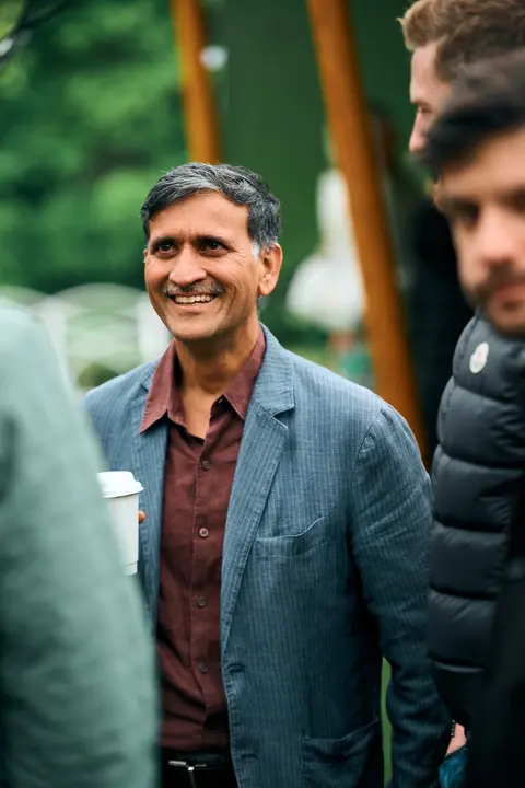 A guest in a grey blazer walking with others