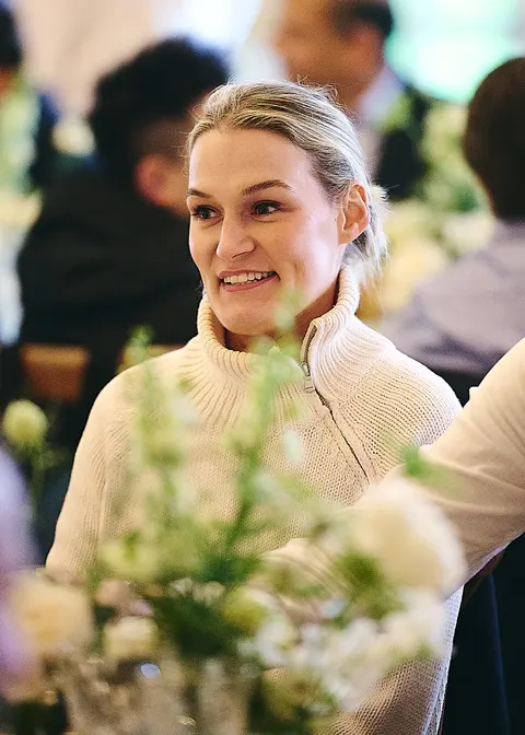 A guest in a cream jumper among white flowers