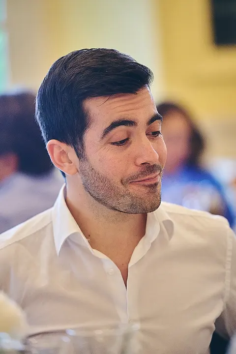 A guest smirking at the dinner table