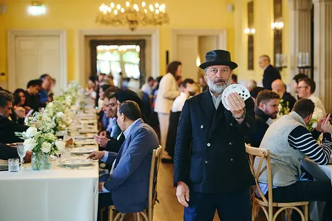 A guest in a hat walking through the busy dining hall