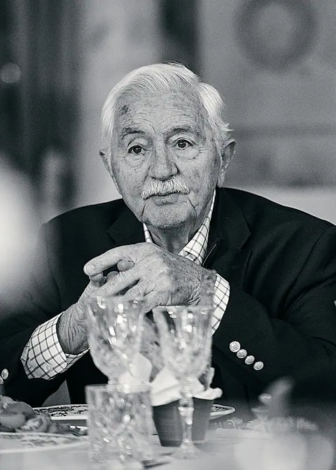Black and white portrait of an older guest at the table with crystal glasses